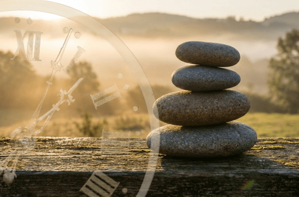 Stones stacked in alignment with a faded clock and a serene background